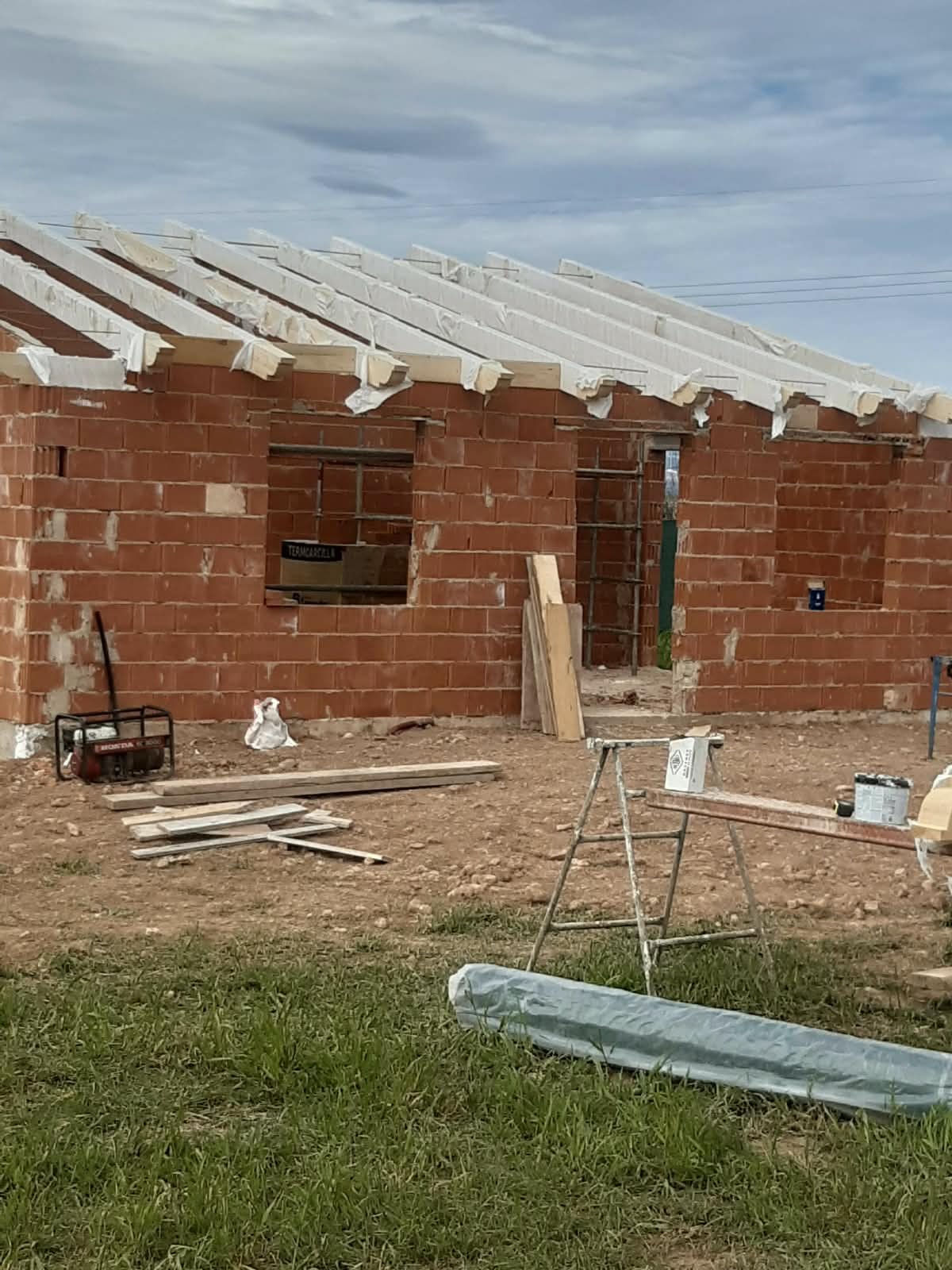 Edificio de ladrillo con la estructura del tejado en ejecución