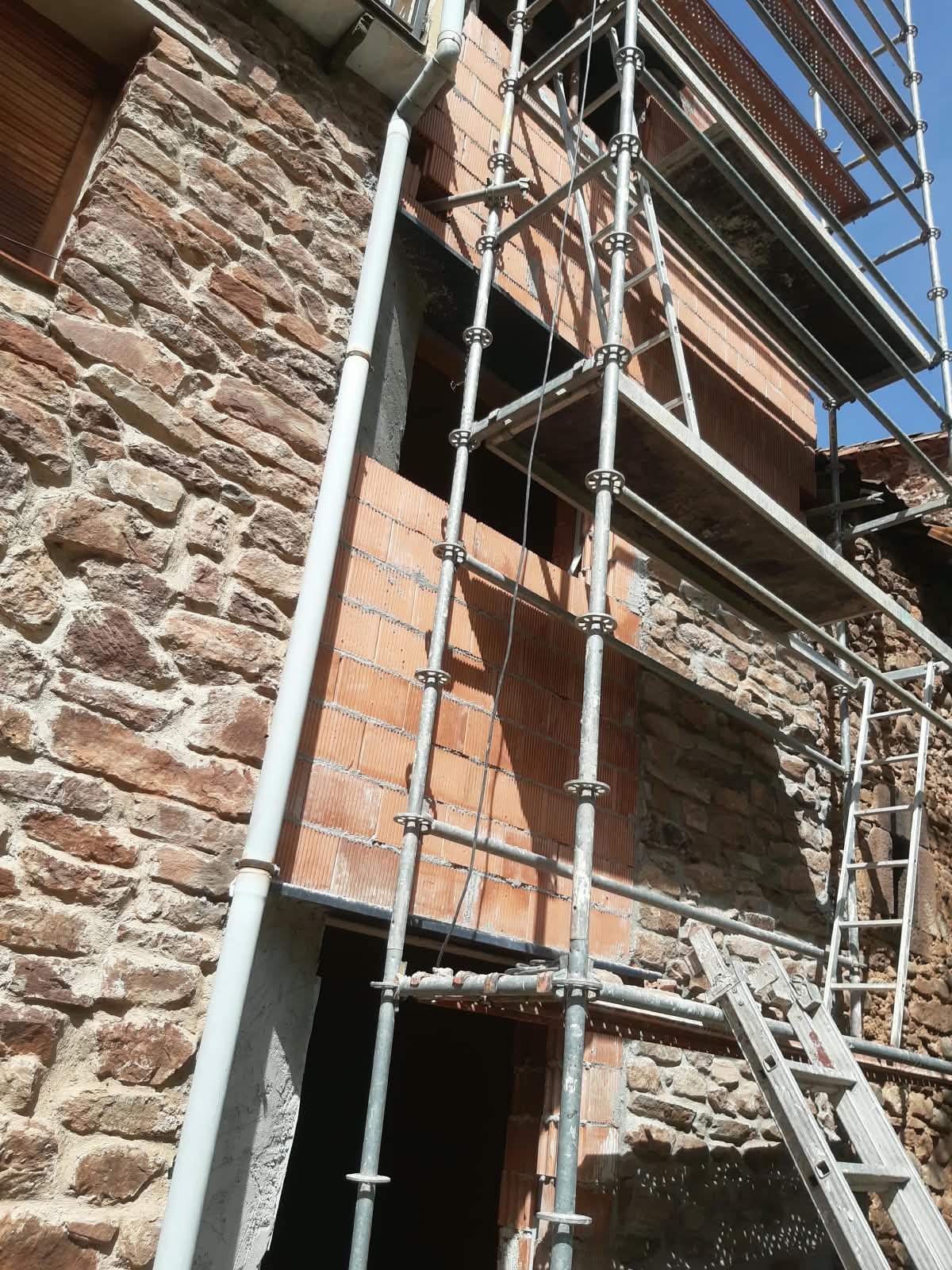 Fachada de piedra en ejecución con andamios